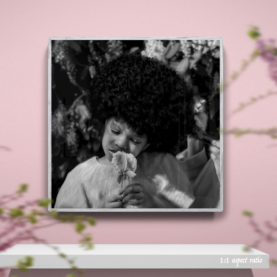Framed black and white photo of a child holding flowers on a pink background