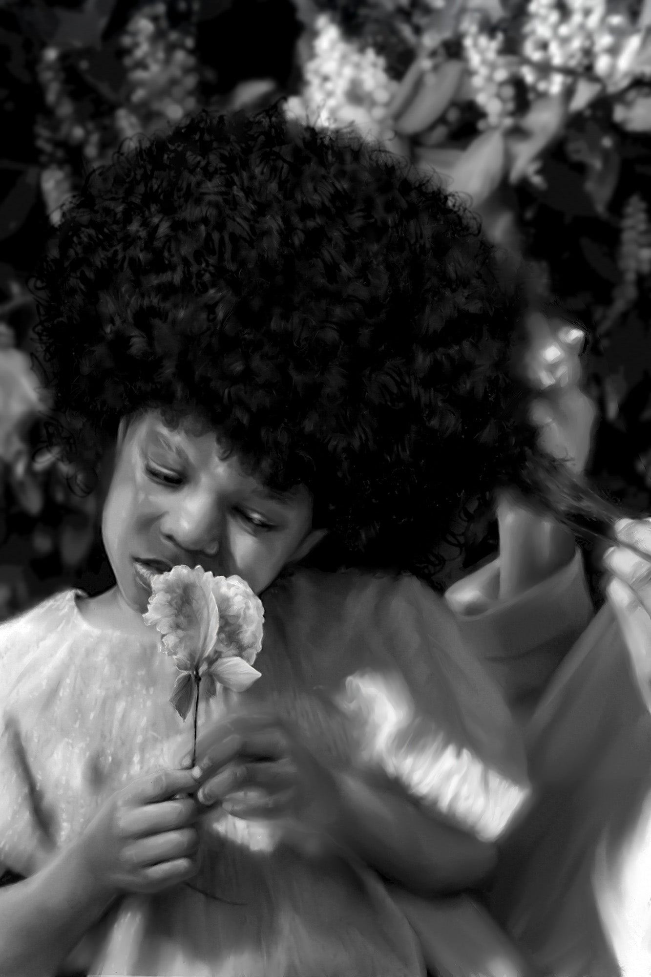 Black and white photo of a child holding flowers with a blurred background