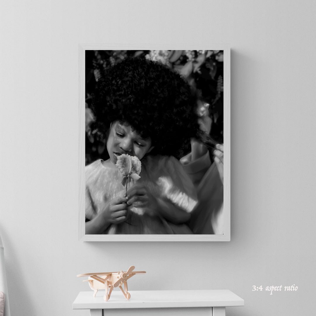 Framed black and white photo of a child holding a flower on a gray wall.