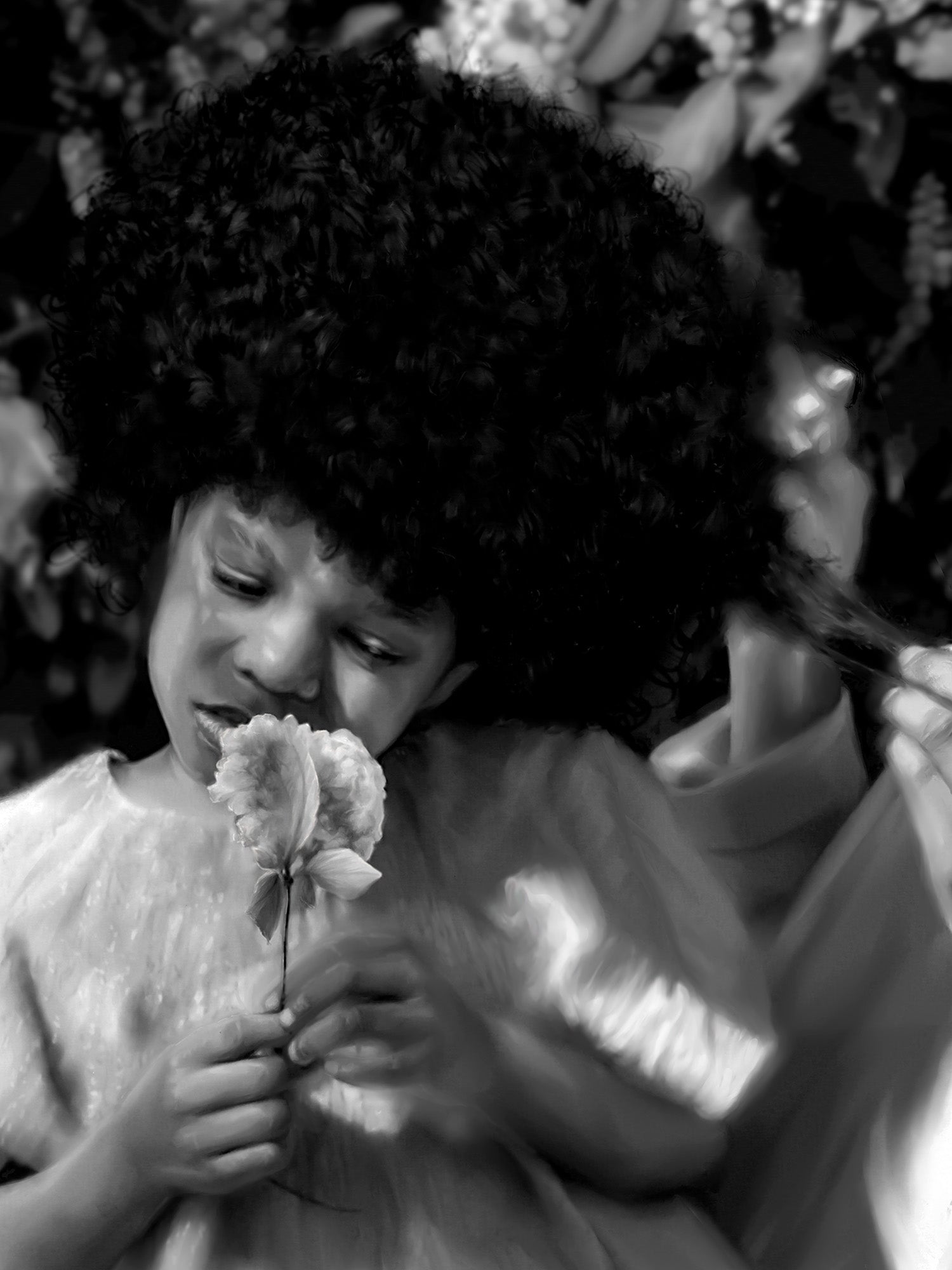 Black and white photo of a child holding flowers with a blurred background