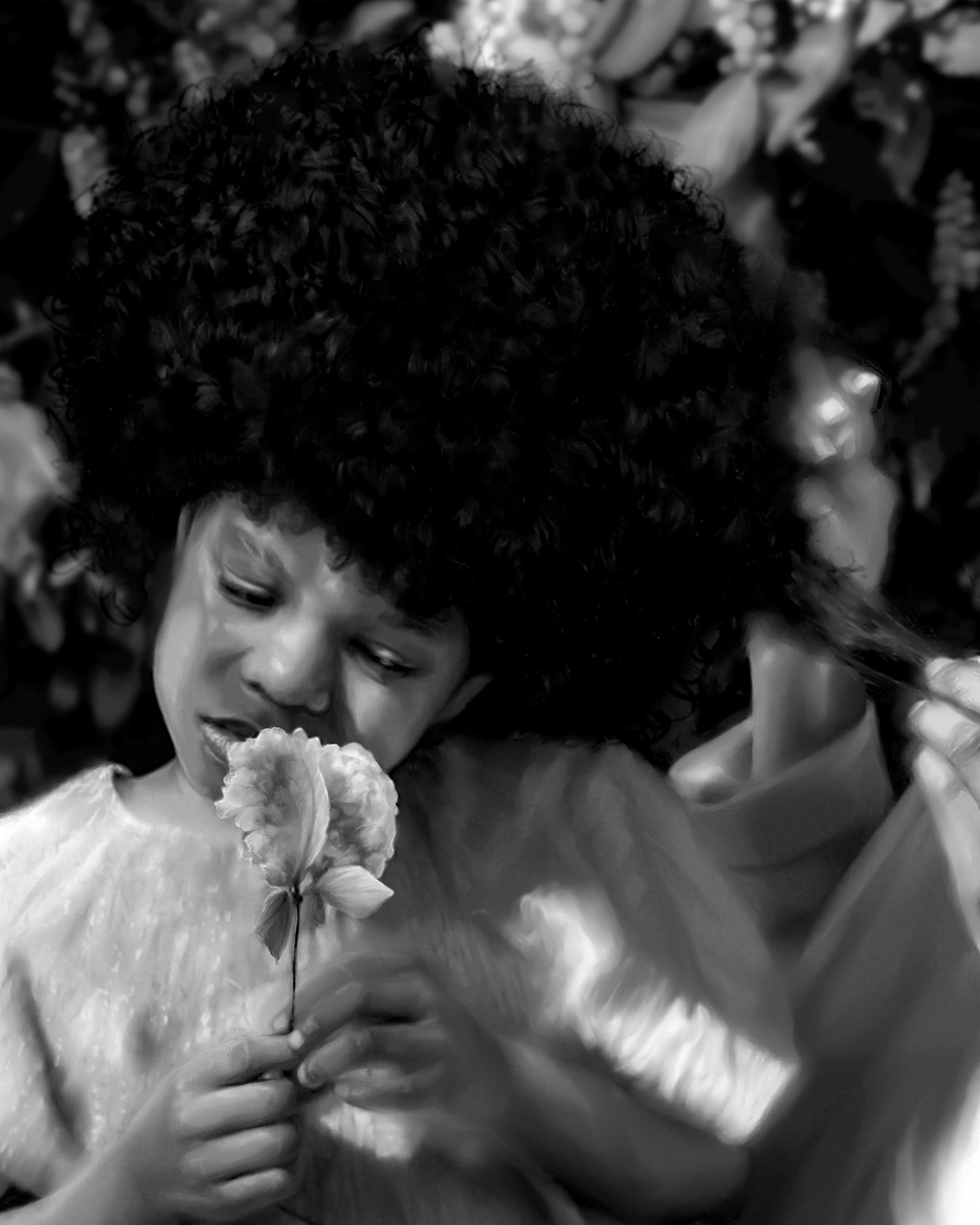 Black and white photo of a child holding a flower with leaves in the background