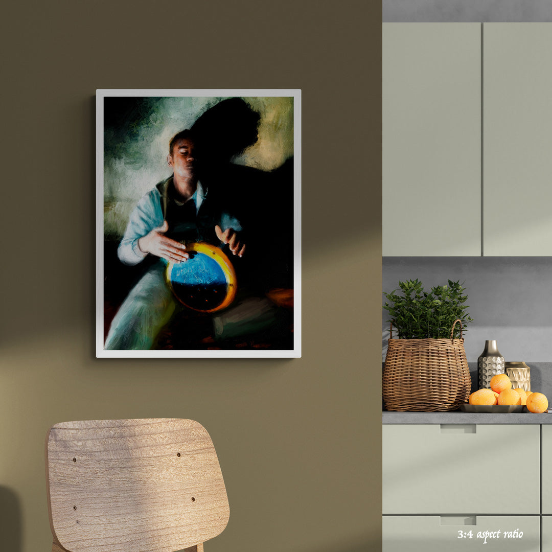 Framed artwork on a wall next to a kitchen with a plant and fruit on the counter.